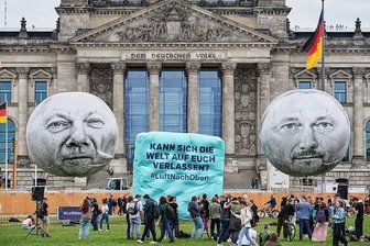 Was Lindner im Bundeshaushalt einplant und was nicht - Aktivisten der Entwicklungsorganisation One lassen vor dem Reichstagsgebäude in Berlin zwei Ballons mit den Konterfeis von Kanzler Olaf Scholz (links) und Finanzminister Christian Lindner (rechts) aufsteigen. Mit der Aktion "#LuftNachOben" soll die Bundesregierung an ihre entwicklungspolitischen Versprechen erinnert werden. 