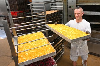 Was sich der beste Chemnitzer Bäckermeister in der Backstube alles einfallen lässt - Der frisch gebackene Bäckermeister Michael Schäfer holt frischen Mangokuchen aus dem Ofen.