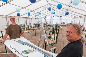 Was zur 700-Jahr-Feier in Dittmannsdorf passiert - Uwe Herzog (rechts) und Philipp Auerswald vom Bauhof Gornau haben am Donnerstag das Festzelt auf dem Dittmannsdorfer Sportplatz eingeräumt und geschmückt. 