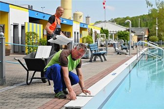 Wasser, Sonne, Spaß: Wann die Freibäder zwischen Rochlitz und Penig öffnen - Saisonvorbereitung im Stadtbad Rochlitz: Jan Kugler (vorn) und Tom Hennig haben am Mittwoch unter anderem die Gitter der Beckenumrandung angebracht. 