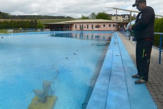 Wasserfreunde bringen ihr Bad auf Vordermann - Jörg Dölling steuert den Unterwasserbodensauger, mit dem das 50-Meter-Schwimmbecken des Freibades Reumten-grün gereinigt wird.