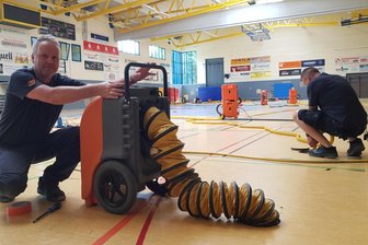 Wasserschaden in Sporthalle: „Das ist der Super-Gau für Oelsnitz“ - Mitarbeiter der Firma SVT Schadensanierung mit ihrer Niederlassung in Neuensalz versuchen, den Hallenboden zu trocknen.