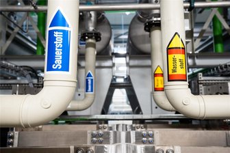 Wasserstoff als Energiequelle? Warum Unternehmen aus dem Erzgebirge noch zweifeln - Auf Rohren einer Wasserstofferzeugungsanlage ist ein Aufkleber mit der Aufschrift Wasserstoff angebracht. Für Unternehmer im Erzgebirge ist das Thema Wasserstoff noch mit Fragezeichen verbunden.