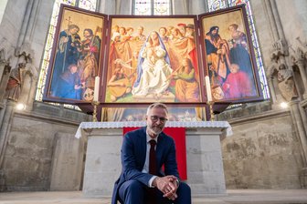 Wechselburger Basilika erhält Meisterwerk von Papstmaler Michael Triegel - Der Leipziger Künstler Michael Triegel sitzt im Dom zu Naumburg vor einem dreiflügeligen Altaraufsatz, für den er den Mittelteil geschaffen hat. Mit seiner Arbeit hat Triegel das 1519 von Lukas Cranach dem Älteren geschaffene und später teils zerstörte Kirchengemälde wieder vervollständigt.