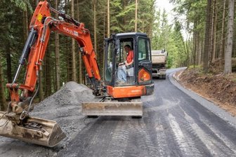 Wege zwischen Wirtschaft und Erholung - Ein Abschnitt des Bärenfangwegs nahe Oberwiesenthal hat in den vergangenen Tagen eine neue Asphaltdecke erhalten. Das Foto zeigt Steffen Schreier bei Anpassungsarbeiten zur Anbindung eines anderen Waldwegs. 