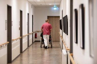 Wegen Antragsstau bei „Hilfe zur Pflege“: Pflegeheime im Vogtland bleiben auf Kosten sitzen - Ein Pfleger und ein Heimbewohner auf eiben Flur im Aspida Pflegecampus Plauen.