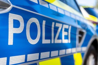 An der Tür von einem Streifenwagen steht der Schriftzug "Polizei".