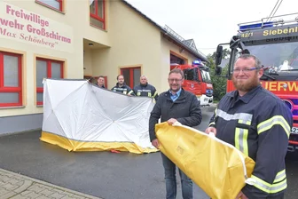 Wegen Gaffern bei Einsätzen: Feuerwehren in Großschirma erhalten Sichtschutzwände - Sichtschutzwände für Einsätze: Michel Einert (r.), amtierender Stadtwehrleiter von Großschirma, und der stellvertretende Bürgermeister Rolf Weigand bei der Übergabe. Hinten Johannes Mocke (l.), stellvertretender Wehrleiter von Siebenlehn, sowie Paul Kretzschmar und Andrè Erler (r.) von der FFW Großschirma.