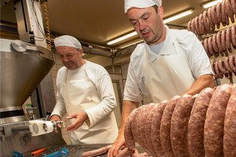 Wegen Lieferengpässen: Plauener Feinkostfirma baut neue Lagerhalle - Mitarbeiter Uwe Zwintzscher (links) und Geschäftsführer Stephan Schmidt bei der Wurstproduktion bei Feinkost-Schmidt.
