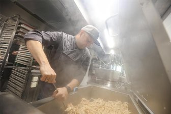 Wegen Mehrwertsteuer: Anbieter von Kita- und Schulessen kündigen nächste Preiserhöhung an - Torsten Weiße-Köhler bereitet Geflügelgeschnetzeltes zu. Seine Firma „Monk-Catering“ beschäftigt insgesamt 50 Mitarbeiter.