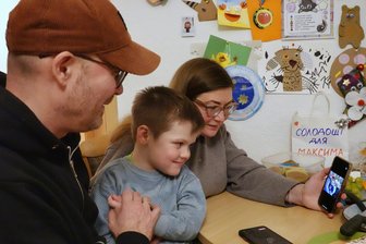 Weihnachten fernab der Heimat: Eine ukrainische Familie zwischen Glück und Heimweh - Dmytro Volkov, Iryna Smirnova und ihr Sohn Maksym schauen sich Weihnachtsfotos aus der Ukraine an.