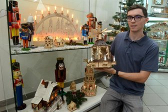 Weihnachtsausstellung lockt in Auerbach die Besucher - Museumsleiter Steve Fiss präsentiert einen Drehturm an einer beleuchteten Vitrine.