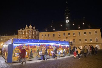 Weihnachtsbaum, Pyramide und Wichtelwerkstatt leuchten auf dem Annaberger Markt - Erste Besucher vor der Wichtelwerkstatt am Freitag.