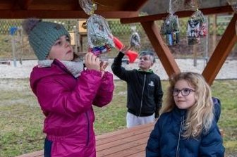 Weihnachtsfreude in Niedersteinbach - Roxy (v. l.), Richard und Louisa holten am Adventssonntag in Niedersteinbach ihre Beutel vom Dach dieser Sitzgelegenheit.