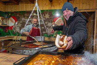 Weihnachtsmärkte im Erzgebirge im Preis-Check: Das kosten Roster, Glühwein, Krapfen und Co. - Ronny Heitmann (r.) und Minas Makris bieten auf dem Marienberger Weihnachtsmarkt unter anderem Thüringer Rostbratwurst an.