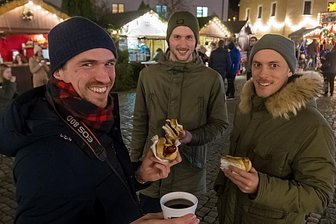 Weihnachtsmarkt im Erzgebirge: Das kosten Glühwein, Bratwurst und gebrannte Mandeln - Alexander Freudenberg, Lukas Porst und Maximilian Beyer (v. l.) aus Rosenheim erkundeten diese Woche den Olbernhauer Weihnachtsmarkt. Dabei probierten sie auch Bratwurst sowie Glühwein. 
