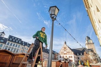 Weihnachtsmarkt in Plauen: Das kommt auf die Autofahrer zu - Marlon Schmidt von der Firma Elektro Schubert installiert auf dem Altmarkt Lampenketten. Die Firma ist für das weihnachtliche Licht auf dem Weihnachtsmarkt, aber auch für das Licht am Weihnachtsbaum auf dem Klostermarkt verantwortlich.