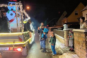 Weihnachtsmobil fährt durch Neukirchen und erntet strahlende Kinderaugen - Immer wieder stoppt das Weihnachtsmobil - nämlich stets dann, wenn am Straßenrand jemand auftauchte. Hier ist es eine Adorfer Familie, die extra auf das Fahrzeug gewartet hat. 