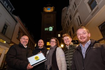 Weil der Werbebannerwechsel am Rathausturm für die Feuerwehr zu gefährlich wurde: Plauen stellt auf digitale Bilder um - Mit einem Druck aufs Knöpfchen hat Oberbürgermeister Steffen Zenner (links) im Beisein von Projektteilnehmern aus der Stadtverwaltung die neue Lichtinstallation am Rathausturm eingeschaltet.