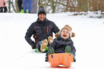 Weiterer Schneefall ist vorhergesagt: Das sind die schönsten Rodelpisten rund um Zwickau - Rodelspaß in Zwickau: Patrick Meyer und Tochter Mia auf dem verschneiten Hang im Planitzer Schlosspark.