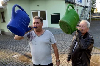 Welche Rolle die Gießkanne bei der Kirmes in Reumtengrün spielt - Uwe Ebert (links) und Horst Schädlich demonstrieren vor dem Sportlerheim, wie Hirsche rufen.