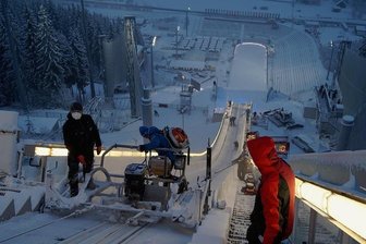 Weltcup-Wochenende unter Corona-Bedingungen: Klingenthaler Wintermärchen wieder ohne Zuschauer - Vorbereitung auf das erste Trainingsspringen: Heiko Krause (links) säubert mit dem Schlitten auf dem Anlaufturm der Vogtland-Arena die Eisspur. Ein gutes Dutzend Helfer hält sie mit Gebläsen schneefrei.