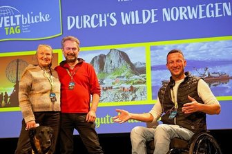 Weltenbummler planen in Plauen Festival für 2022 - André Czinkewitz (rechts) begrüßte in der Festhalle zur Weltblicke-Tag-Premiere Siglinde Fischer und Walter Steinberg (links). Das Paar reiste mit Hundedame "Motte" durchs wilde Norwegen. 