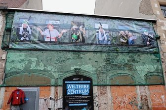 Welterbezentrum: Planungen laufen an - Ein Banner kündet an den Resten der Fassade des Hauses Petersstraße 19, dass hier das künftige Freiberger Welterbezentrum entstehen wird. Das Gebäude rechts daneben wird dabei mit einbezogen.