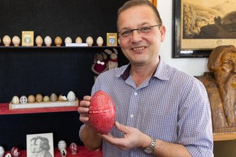 Weltliteratur und Liedtexte auf Eiern: Museum im Erzgebirge zeigt spezielle Ostereier-Kollektion - Museumsleiter Lutz Röckert zeigt ein Straußenei mit Schillers „Die Bürgschaft“.