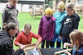 Weniger Feste: Was sich im Freilichtmuseum ändern wird - Wie war Wäschewaschen früher? Kinder in Eubabrunn mit Museumspädagogin Romy Bauch (vorn links).