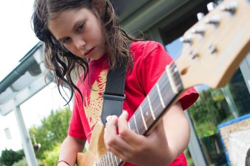 Weniger Klassik, bitte: Wie man Kinder für Musik begeistert! - Ein Mädchen an der E-Gitarre? Einfach mal versuchen!