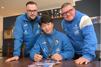 Wenn auch nur für Autogramme: Olympiasieger aus Japan kehrt gerne zu den Ringern des AC 1897 Werdau zurück - Marco Olschewski (links) und Mario Uhlig (rechts) vom Vorstand des AC Werdau freuten sich über das Wiedersehen mit Nao Kusaka.