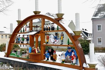 Wenn der Lack abplatzt: Wer pflegt die Freiluft-Pyramiden und Schwibbögen in der Region? - Das Besondere am Saydaer Schwibbogen: Die Figuren sind mit deckenden Farben bemalt und leuchten daher besonders intensiv. Zu sehen ist in der Mitte die biblische Geschichte, rechts Kurrendesänger, Nussknacker und diverse Räuchermänner; links Engel und Bergmann, Striezelkinder, Pilzsammler, Markthändler sowie Stadtkirche, Wasserturm und das Museum von Sayda. Arndt Lorenz (r.) hat den Schwibbogen einst mit gebaut; Mirko Beer (l.) hilft seit Jahren mit, die Figuren in Schuss zu halten.