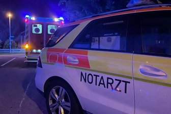 Wenn jede Sekunde zählt - Ein Notarztfahrzeug und ein Rettungswagen parken bei Dunkelheit vor einem Wohnhaus (Symbolbild, keine echte Parksituation). Bei einem Einsatz im Raum Flöha konnte ein Autofahrer die Straße nicht passieren und verwickelte die Rettungskräfte daraufhin in eine Diskussion. 