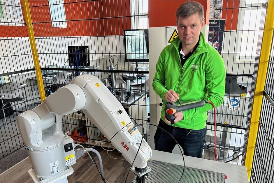 Werdau: Azubis lernen nun den Kollegen Roboter bedienen - Ausbilder Thomas Unger erklärte den Gästen im neuen Fachbereich die Funktionsweise und Einsatzmöglichkeiten des Knickarmroboters. Monotone Handgriffe wie das Bewegen von Teilen übernimmt nun Kollege Roboter.