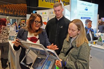 Westsachsen sparen nicht am Urlaub: „Reisen ist Luxus, wenn man guckt, wo die Preise hingehen“ - Uta Illing (links) berät auf der Zwickauer Reisemesse Richard Büchner und Lena Leonhardt, was eine Kreuzfahrt Richtung Island kosten würde.