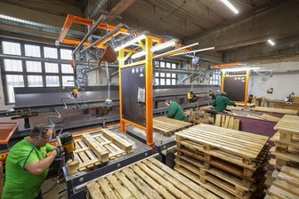 Westsächsischer Paletten-Hersteller investiert in Recycling-Anlage - Mitarbeiter der Firma A.P. Paletten Recycling Remse, im Vordergrund David Sünderhauf, haben es dank der neuen Anlage leichter, die gebrauchten Paletten zu reparieren.