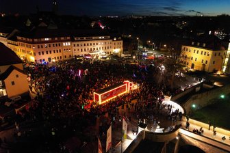Wie Bergstadtfest, nur im Winter: Coca-Cola-Truck mobilisiert Massen in Freiberg - mit Drohnenvideo - Luftaufnahme vom 16. Dezember 2025 in Freiberg. Der Coca-Cola-Truck zieht tausende Besucher an. Im Dunkeln kam der beleuchtete Truck nochmal anders zur Geltung als tagsüber.