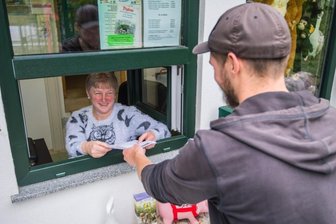 Wie bitte komme ich in den Tierpark rein? - Im Zoo der Minis in Aue erfolgt der Einlass sehr flexibel. Hier nimmt Kassiererin Petra Hörenberg die ausgedruckte Reservierungs-Mail eines Besuchers entgegen. Sie dient der Kontaktnachverfolgung. Wer daheim keinen Drucker hat, kann das Formular auch an der Kasse ausfüllen.