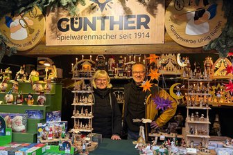 Wie der Weihnachtsmann auf dem Striezelmarkt einer Handvoll Erzgebirger den Heiligabend rettete - Dort passieren noch wahre Weihnachtsgeschichten: Verkäuferin Elke Boy mit Holzkunsthersteller Tino Günther auf dem Dresdner Striezelmarkt.