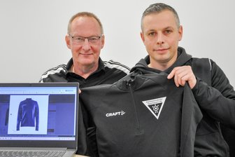 Wie die Hartmannsdorfer Fußball-Jugend zu neuer Teamkleidung kommt - Vereinschef Thomas Fittkau (links) und Jugendleiter Patrick Schmieder zeigen am Bildschirm und an einem Mustershirt mit dem Logo des HSV 05, wie die neuen Aufwärmshirts für den Fußball-Nachwuchs aussehen.