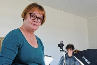 Wie die Zünfte ihre Särge schmückten - Restauratorin Annegret Michel zeigt das Schild der Schuhmacher. Im Hintergrund fotografiert Volker Distel. 