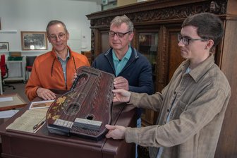 Wie dieses kuriose Musikinstrument von Hessen ins Vogtland zurückkommt - Hans-Günter Spitzbarth (Mitte) hat Auerbach die Violinzither geschenkt. Kersten Wober vom Museumsverein (links) und Archivleiter Steve Fiß sind glücklich.