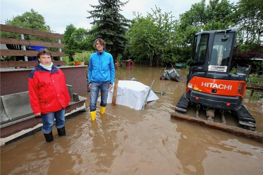 Wie eine Glauchauer Familie das Hochwasser verarbeitet hat - Sandra Koch, damals hochschwanger, und Jens Schumann stehen 2013 auf ihrem neuen Grundstück mitten im Wasser.