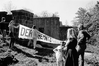 Wie geht es der Chemnitz heute? Künstler erinnern an Umweltprotest von 1990 - Im April 1990 spannten Umweltschützer dieses Banner am Neumühlenwehr über die Chemnitz. Daran soll ab Samstag im Rahmen der Ausstellung „Gegenwarten“ erinnert werden.