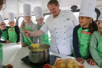 Wie Kartoffeln den Unterricht schmackhaft machen - In einem sogenannten Kochbus zeigt Koch Martin Schneider den Niederfrohnaer Schülern, wie vielfältig die Kartoffel zubereitet werden kann. Dabei wurden die Kinder selbst aktiv, schälten und schnitten die Knollen. 