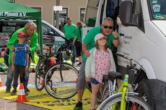 Wie Plauener Vorschulkinder auf Verkehrsgefahren aufmerksam gemacht werden - Um den Toten Winkel ging es am Stand von Uwe Apel, der mit Lara und Fahrschullehrer Michael Marscheider (links) mit Emil von der Kita Sonnenschein die Sichtbarkeit im Rückspiegel testete.