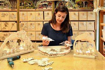 Wie sich Kunsthandwerker aus dem Erzgebirge auf der Christmasworld präsentieren - Produktentwicklerin Cathleen Müller arbeitet an einem Ratags-Schwibbogen. 