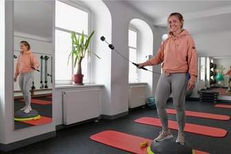 Wie Sport bei Long Covid helfen kann - Übungsleiterin Christin Walter vom Fitnessstudio "Aktiv am Dom" in Freiberg demonstriert eine Schwingstab-Übung im Kursraum, die auch im Rehasport trainiert wird.