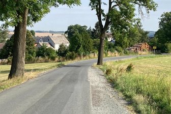 Wie weiter mit der Lauterbacher Straße in Schönbrunn? - Die Lauterbacher Straße zwischen Hohen Kreuz und Schönbrunn (im Hintergrund) ist schmal, Bankette brechen tief ab, die Belastung durch schwere Fahrzeuge ist Dauerthema. Noch im Juli soll es einen Ortstermin zur Gemeindestraße geben.